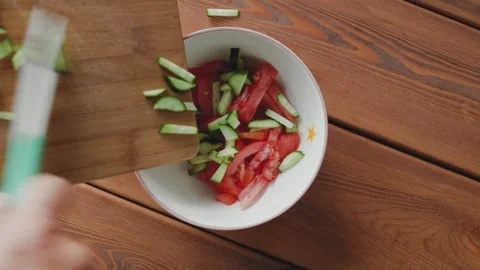 Male hands adding slice cucumber to salad Stock Footage 246881398