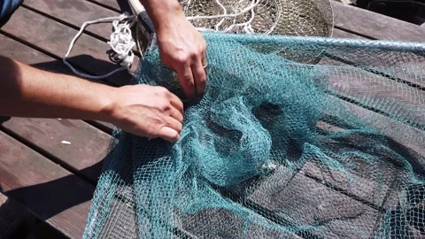 Male hands are fingering checking fishing accessories tackle on old wooden table Stock Footage 142492859