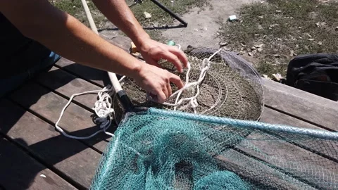 Male hands are fingering checking fishing accessories tackle on old wooden table Stock Footage 142492872