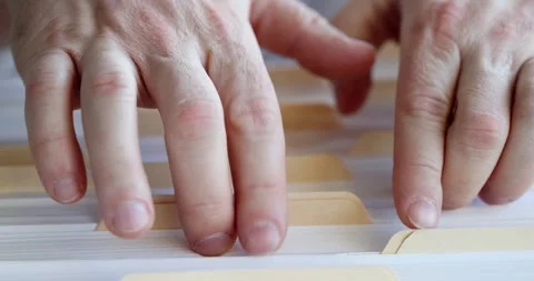 Male hands are sorting through folders with documents in filing cabinet Stock Footage 252659169