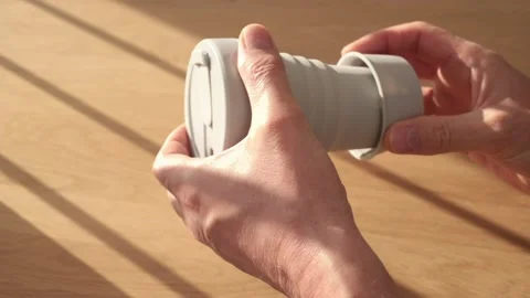Male hands assembling eco-friendly reusable silicon collapsible folding coffee Stock Footage 154964642