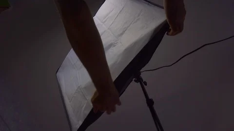 Male hands assembling a softbox, close up, photo shooting set, behind the scene Stock Footage 105470791