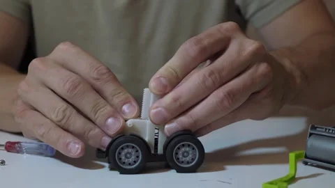 Male hands assembling toy car wheels Stock Footage 340015905