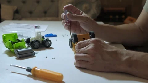 Male hands assembling toy with screwdriver Stock Footage 340015960