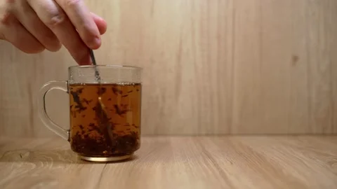 Male hands begin to stir tea with a spoon. Tea swirl in a cup for a long time Stock Footage 151890783