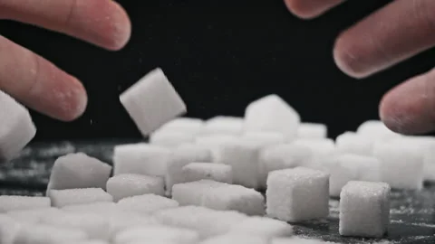 Male Hands Bend Sugar Cubes Into a Pile on a Black Table in Slow Motion Stock Footage 264139366