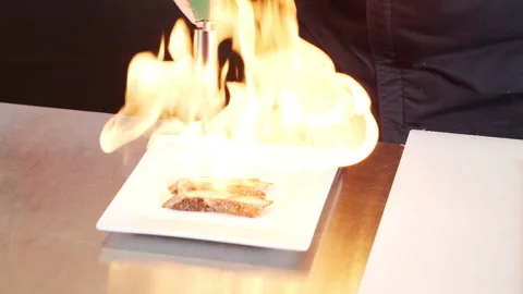 Male hands burning slices of fresh tuna with smoked fire using a gas burner Stock Footage 142151753