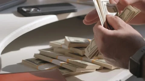 Male hands counting dollar banknotes sitting in room at table. Banking and Stock Footage 254460149