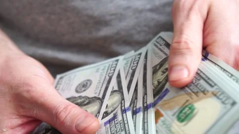 Male hands counting a stack of hundred-dollar US banknotes. Concept of Stock Footage 241327191