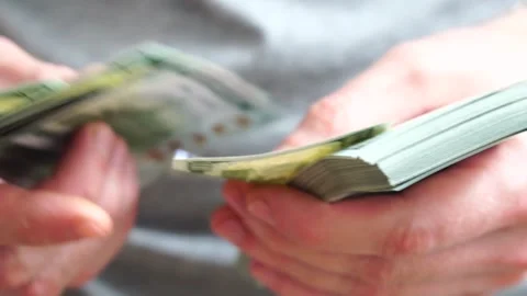 Male hands counting a stack of hundred-dollar US banknotes. Concept of Stock Footage 241652682