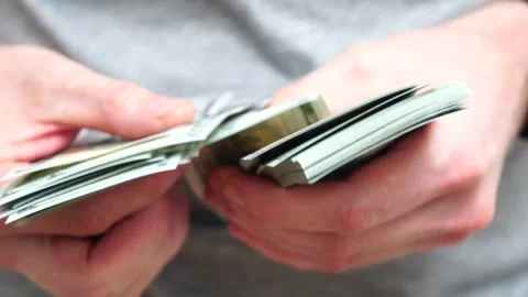 Male hands counting a stack of hundred-dollar US banknotes. Concept of Stock Footage 241994803