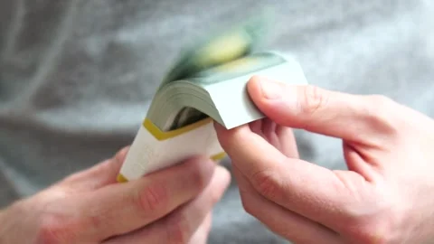 Male hands counting a stack of hundred-dollar US banknotes. Concept of Stock Footage 243417955