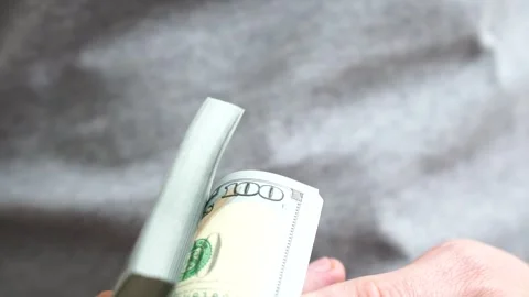 Male hands counting a stack of hundred-dollar US banknotes. Concept of Stock Footage 245895853