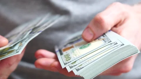 Male hands counting a stack of hundred-dollar US banknotes. Concept of Stock Footage 246620271