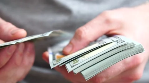 Male hands counting a stack of hundred-dollar US banknotes. Concept of Stock Footage 246670137