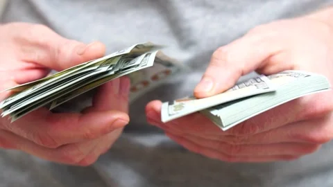 Male hands counting a stack of hundred-dollar US banknotes. Concept of Stock Footage 246996652