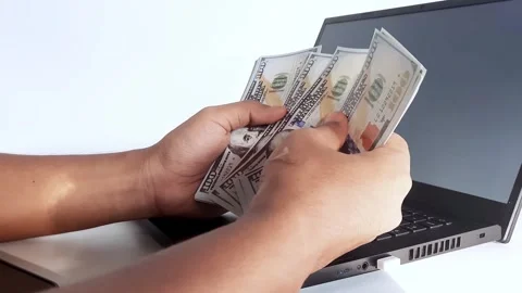 Male hands counting US dollar banknotes at the table in front a laptop computer Stock Footage 294185310