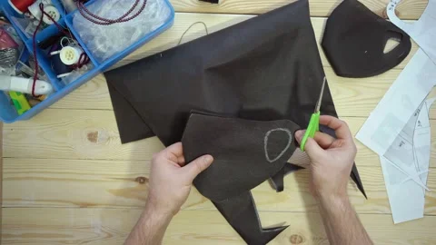 Male hands cut out pattern mask with scissors. Stock Footage 130708232