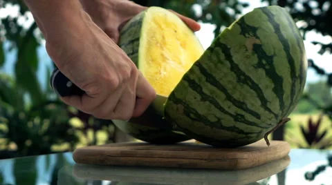 Male hands cutting melon on table in the garden, super slow motion Stock Footage 67504618