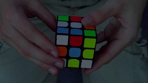 Male Hands Fast Solve Twisty Puzzle from Above with Dark Overlay Stock Footage