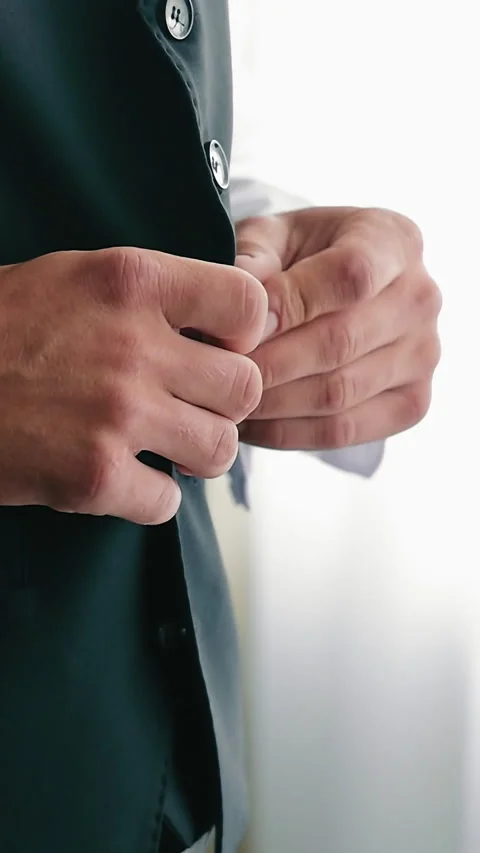 Male hands fasten a button on a jacket. Close up. The groom fastens his jacket Video stock 340575720