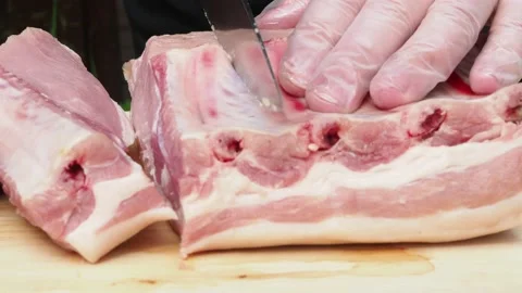 Male hands with gloves on cut the meat on the bone with a knife. Stock Footage