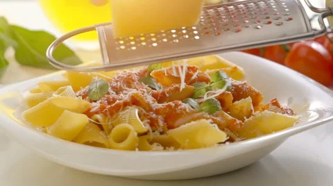 Male hands grating cheese over penne pasta Stock Footage 67993705