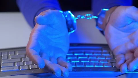 Male hands in handcuffs and computer keyboard close up. Front view Stock Footage 124005696