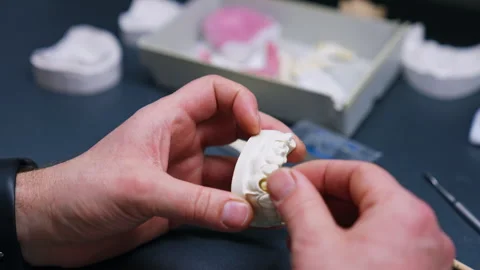 Male hands hold the plastic denture. Stock Footage 256365975