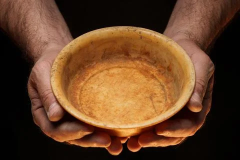 Male hands holding empty plate on dark background, lack of food, hunger concept. Stock Photos
