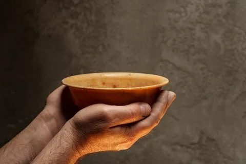 Male hands holding empty plate on dark background, lack of food, hunger concept. Stock Photos