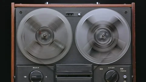 Vintage Reel To Reel Tape Recorder Playing Against a Black Studio