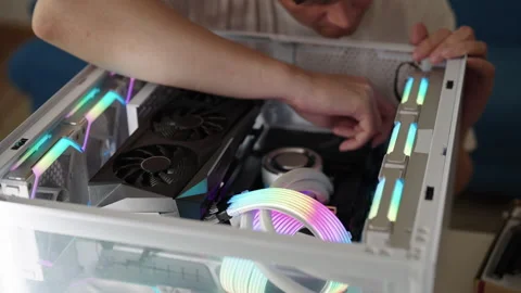 Male hands installing components and routing colorful rgb cables inside a Stock Footage 318468358