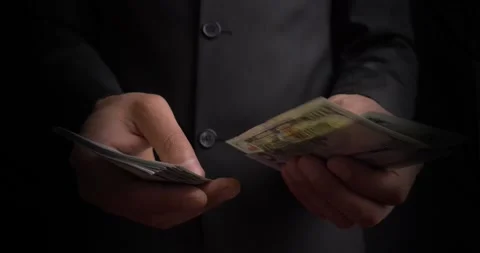 Male hands leisurely count a stack of paper bills into one hundred dollar bills Stock Footage 271035553