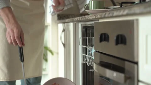 Male hands is loading dirty plates into a dishwasher machine. Stock Footage 196598596