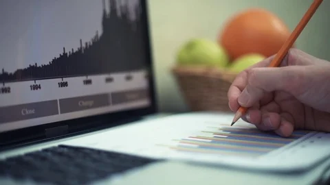 Male hands making note with pencil at printed analyzing graphs Stock Footage 82934266