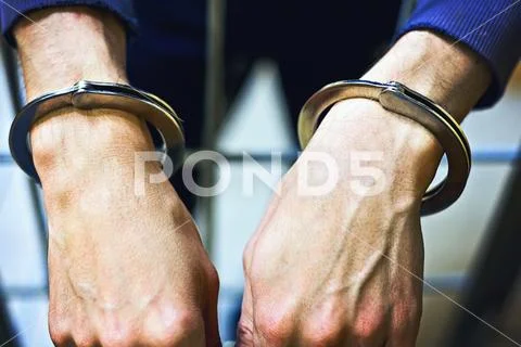 Male hands in metal handcuffs closeup. A prisoner in jail. the concept of pun Stock Photos