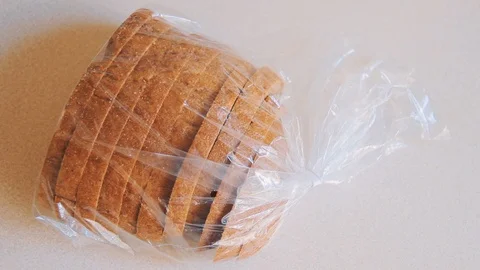 Male hands open plastic latch on bag with bread on the table Stock Footage 108009829