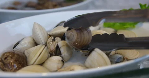 Male hands open a shell, taking out a clam, showing how to open a shell Stock Footage 276576616