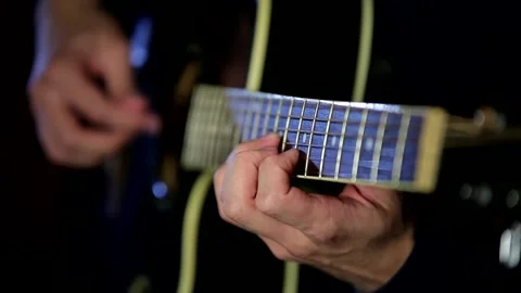Male hands playing the guitar with a refocus from one hand to another Stock Footage 201284982