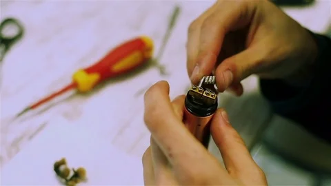 Male hands preload coils of the electronic cigarette. Stock Footage 73178080