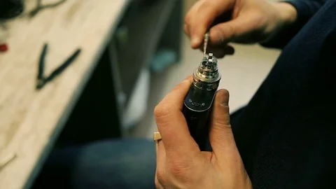 Male hands preload spirals for e-cigarette. Stock Footage 72930151