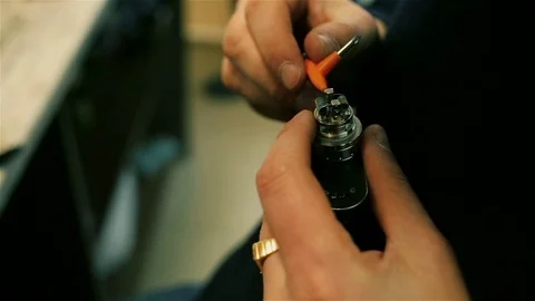 Male hands preload spirals for e-cigarette. Stock Footage 72930187