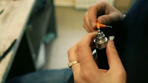 Male hands preload spirals for electronic cigarette. Stock Footage 72933095