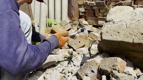 Male hands in protective gloves uses hammer to remove old cement from used brick Vídeos de archivo 337189451