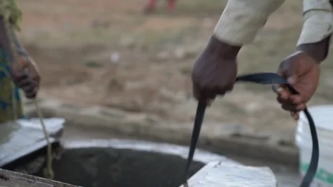 Male hands pull a bucket of dirty water from the well Stock Footage 100903239