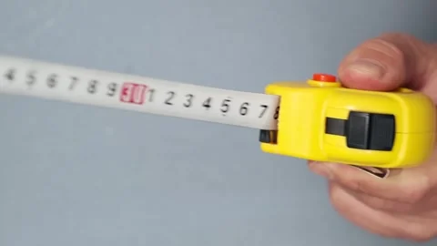 Male hands pull the measuring tape out of tape measure and release it Stock Footage 253971181