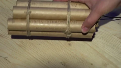 Male hands put a bundle of dynamite with a wick on the table. Stockbeeldmateriaal 135540501