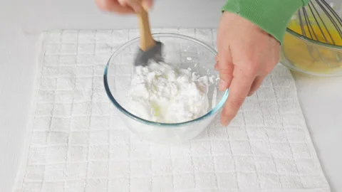 Male hands put ready-made whipped meringue protein in glass bowl wooden spatula. Stock Footage 231900592