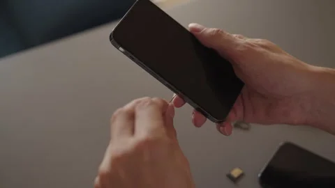 Male hands replacing nano sim card, insert into tray for new smartphone Stock Footage 321296677